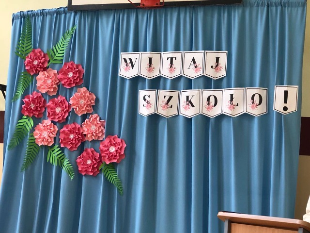 Dekoracja apelu rozpoczęcia roku szkolnego: kwiaty i napis "Witaj szkoło!"