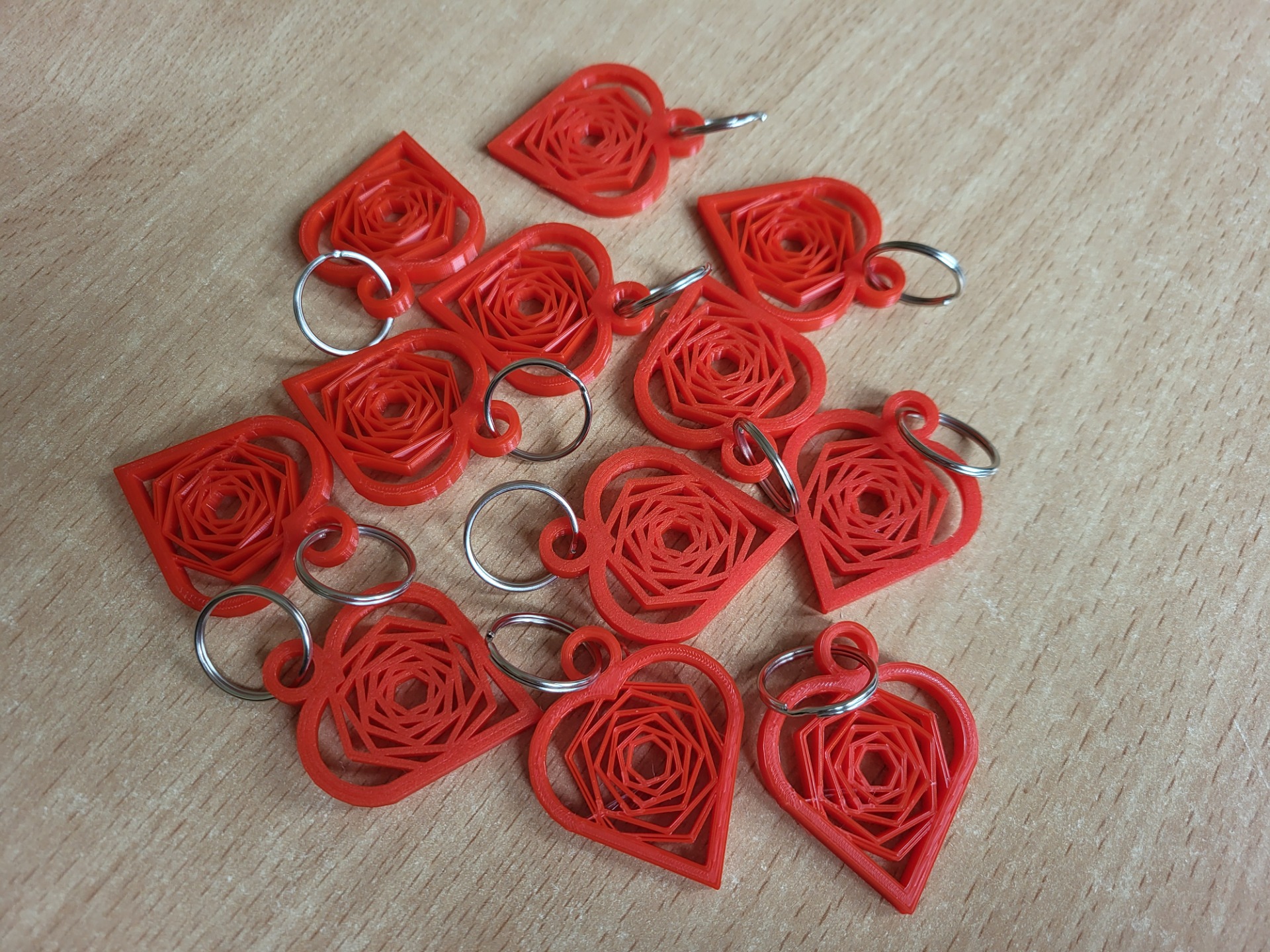 Czerwone breloczki w kształcie serca wykonane na drukarce 3D na srebrnym kółeczku do kluczy.